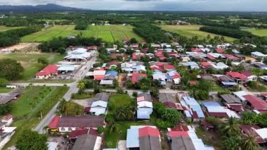 Sungai Chenaam köyünde evleri, yolları ve pirinç tarlalarını gösteren hava manzarası var..