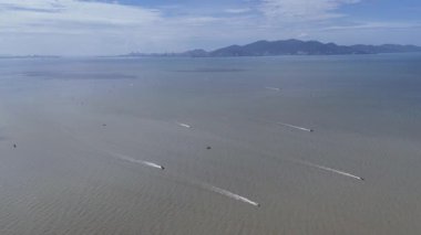 İnsansız hava aracı görüntüleri Pennag kıyı şeridi yakınlarındaki sakin denizde çoklu balıkçı tekneleri ve uyanma şekilleri gösteriyor..