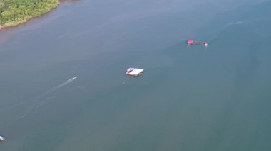 Tekne bir evin yakınında suda yüzüyor. Su sakin ve gökyüzü Johor Nehri 'nde berrak.