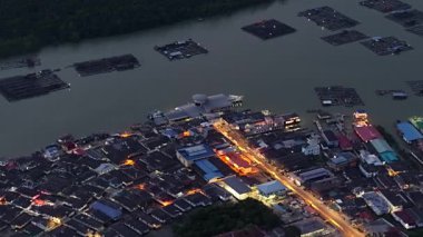 Gece gökyüzünün altında parlayan Kukup konutlarının insansız hava aracı perspektifi.