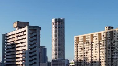 Şehrin ufuk çizgisi Macallum Kulesi 'nin merkezindedir. Temiz gökyüzünün altında daha eski ve daha yeni konutlarla çevrelenmiştir.