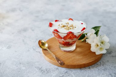 Gri bir masada taze meyve ve yoğurtla sağlıklı bir kahvaltı. Yulaf ezmeli tatlı. Doğal beslenme. Panakot. Yakın plan..