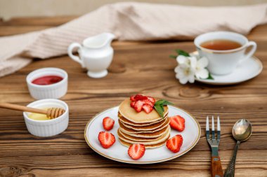 Sağlıklı yaz kahvaltısı, ahşap zemin üzerinde taze böğürtlen ve bal olan ev yapımı klasik Amerikan krepleri. Lezzetli hamur işleri, tatlı..