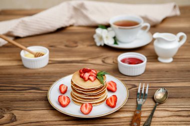 Sağlıklı yaz kahvaltısı, ahşap zemin üzerinde taze böğürtlen ve bal olan ev yapımı klasik Amerikan krepleri. Lezzetli hamur işleri, tatlı..
