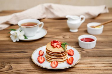 Sağlıklı yaz kahvaltısı, ahşap zemin üzerinde taze böğürtlen ve bal olan ev yapımı klasik Amerikan krepleri. Lezzetli hamur işleri, tatlı..
