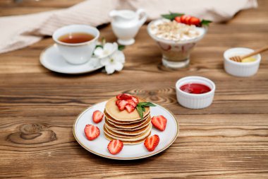 Sağlıklı yaz kahvaltısı, ahşap zemin üzerinde taze böğürtlen ve bal olan ev yapımı klasik Amerikan krepleri. Lezzetli hamur işleri, tatlı..