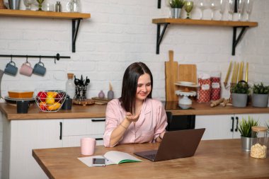 Uzaktan kumanda. Kadın bilgisayar ekranına bakar, jestler ve gülümsemeler. Uzaktan öğrenme, eğitim ve çalışma. Öğrenci sınavlara hazırlanıyor..