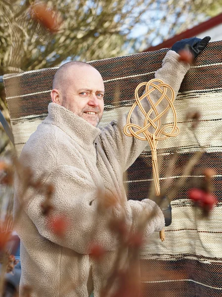 Man and carpet beater — Stock Photo, Image