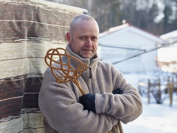 Man and carpet beater — Stock Photo, Image