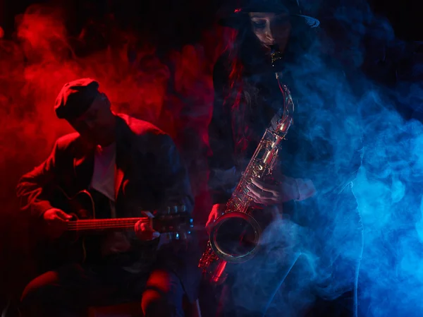 Beautiful young woman plays saxophone — Stock Photo, Image