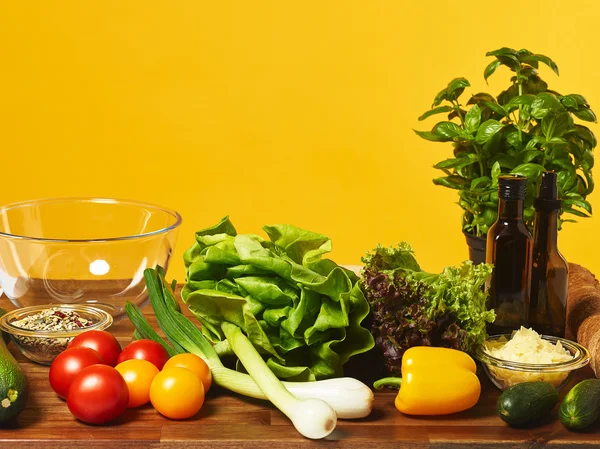 Fresh salad ingredients and yellow background — Stock Photo, Image