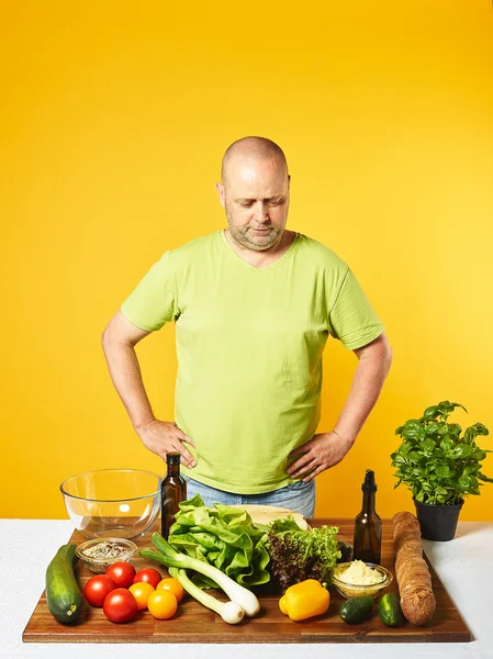Uomo di mezza età cucinare insalata fresca — Foto Stock