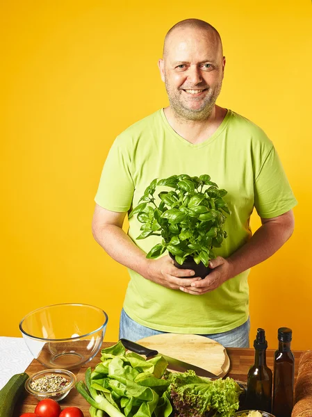 Uomo di mezza età cucinare insalata fresca — Foto Stock