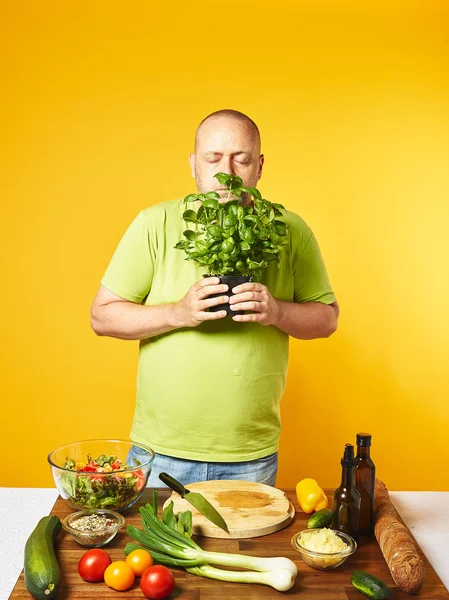 Mann mittleren Alters kocht frischen Salat Stockbild