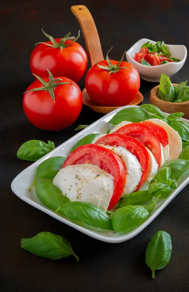 バッファロー モッツァレラとカプレーゼと呼ばれるイタリアのサラダアンティパスト オリーブオイルとトマトとバジル — ストック写真