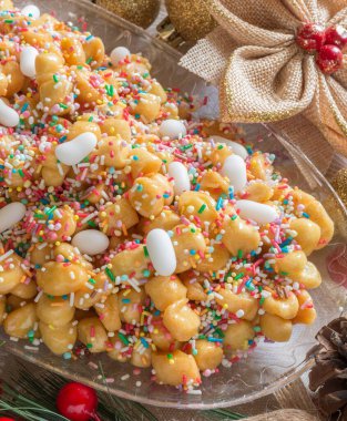 Adı struffoli olan Napoli hamur işi, balın içinde kızartılmış küçük kısa hamurlu hamur topları.