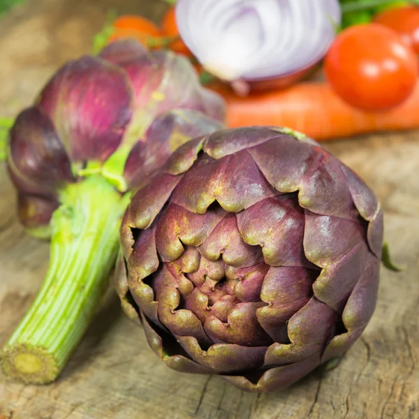 Artichokes on wooden table — Stock Photo, Image