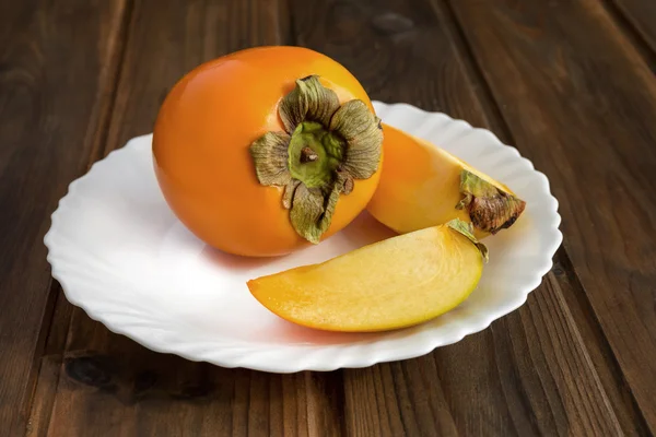 Kaki fruits on wooden table — Stock Photo, Image