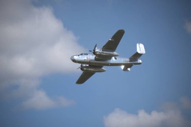 Bulutlu mavi gökyüzünde uçan eski savaş uçağı