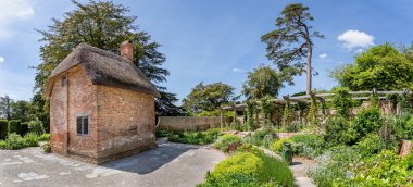 Colourful cottage gardens and cottage at The Newt, near Bruton, Somerset, UK on 15 June 2021