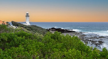 Norah Head Deniz fenerinin panoramik manzarası ve Pasifik Okyanusu 'nu Norah Head, NSW, Avustralya' da 11 Ocak 2026 'da kesen antik kaya platformu.