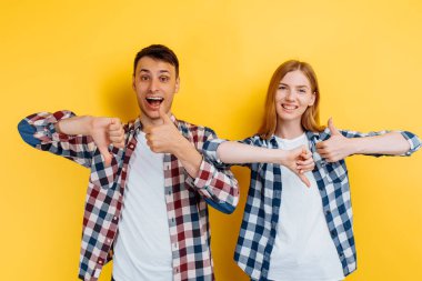 Tanımlanamayan genç çift, anlaşmazlık, erkeğin oyu, kadının oyu, sarı arka planda