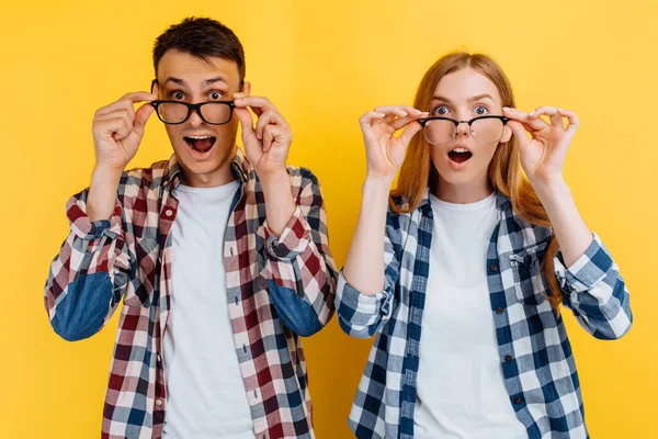 幸せな若い興奮した人々 黄色の背景にビジョンのための眼鏡をかけて男と女 — ストック写真