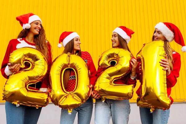 Grupa Wesołych Młodych Kobiet Kapeluszach Świętego Mikołaja 2021 Balonami Tle — Zdjęcie stockowe