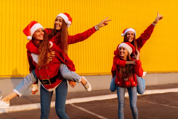 Wesołe Dziewczyny Noszące Czapki Świętego Mikołaja Bawiące Się Jeżdżące Świeżym — Zdjęcie stockowe