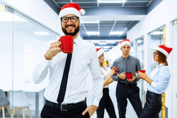 Jovem Homem Negócios Vestindo Chapéu Papai Noel Segurando Uma Caneca — Fotografia de Stock