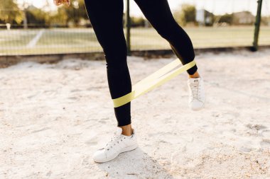 Spor yapan kadın spor yapıyor spor için elastik bant ile parkta.