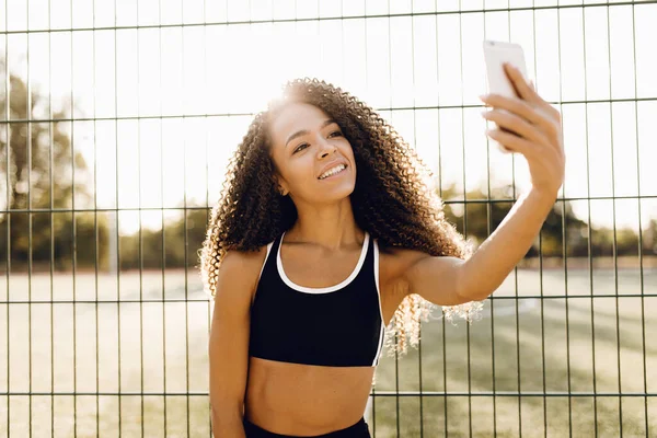 Sporty smiling runner, woman taking selfie on mobile phone, outdoors in park, healthy lifestyle