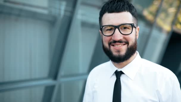 Homme d'affaires, heureux jeune homme d'affaires avec barbe portant des lunettes, en plein air dans la ville — Video