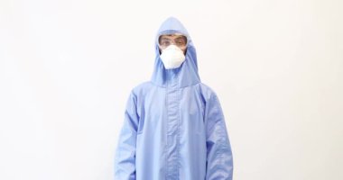 Koronavirüse karşı koruyucu giysi giymiş, tıbbi maske, gözlük ve eldiven takmış, kolları beyaz bir arka planda çaprazlanmış bir erkek doktor. Karantina, koronavirüs