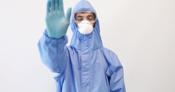 보호용 양복,마스크, 안경, 장갑을 끼고 있는 의사는 STOP 제스처 , 감염 중단 , 의학과 건강 관리를 보여 주고 있다. — 비디오