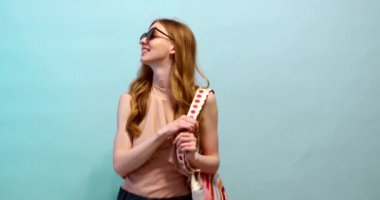  Güneş gözlüklü mutlu kadın ve mayo denize gider.