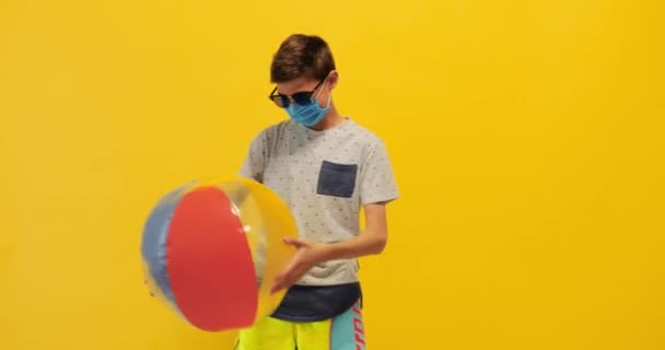 Šťastný teenager oblečený v ochranné lékařské masky stojí s — Stock video