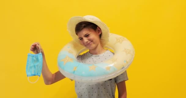 Adolescente descontento en un sombrero de verano con un anillo inflable pone — Vídeos de Stock