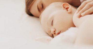 Güzel, genç bir annenin ve tatlı bebeğinin yan görüntüsü. 