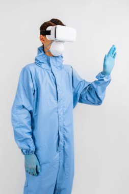Coronavirus 'a karşı korumak için tıbbi maskeli ve üniformalı bir doktor, tıpta sanal gerçeklik gözlüğü kullanıyor. Modern teknolojiler, tıp