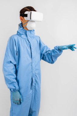 Coronavirus 'a karşı korumak için tıbbi maskeli ve üniformalı bir doktor, tıpta sanal gerçeklik gözlüğü kullanıyor. Modern teknolojiler, tıp