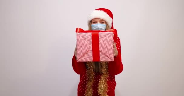Привлекательная молодая женщина в рождественской шляпе Санта Клауса, носит медицинское — стоковое видео