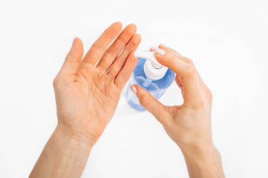 Disinfection of hands. Man applying antiseptic spray to his hands to prevent coronavirus or flu, on white background