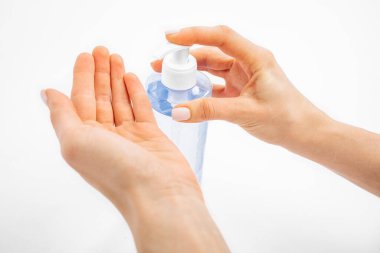 Disinfection of hands. Man applying antiseptic spray to his hands to prevent coronavirus or flu, on white background