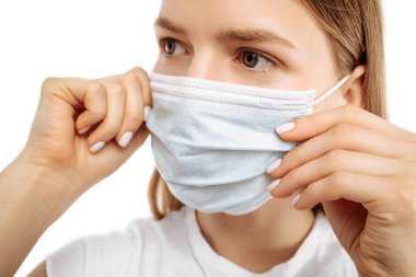 Young woman using medical protective mask to protect health and prevent influenza virus, epidemic and infectious diseases, on white background
