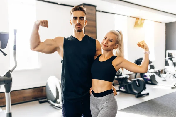 Retrato Jovem Casal Juntos Sportswear Mostrando Bíceps Enquanto Ginásio Conceito — Fotografia de Stock