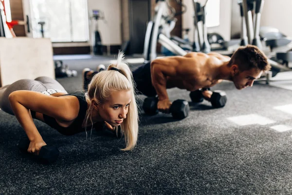 Młoda Para Kobiet Muskularny Mężczyzna Ćwiczą Siłowni Tworzenie Deski Kettlebell — Zdjęcie stockowe