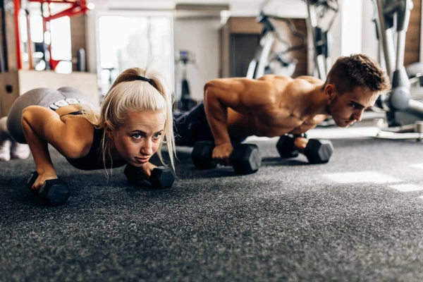 Młoda Para Kobiet Muskularny Mężczyzna Ćwiczą Siłowni Tworzenie Deski Kettlebell — Zdjęcie stockowe