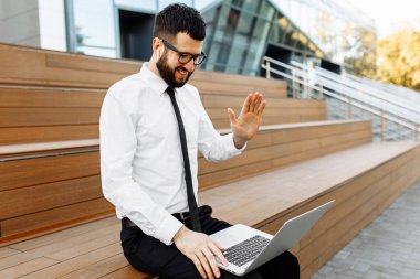 Bilgisayarı kullanan ve video konferansında iş arkadaşlarıyla konuşan bir iş adamı. Video görüşmesi sırasında bilgisayar kullanan bir iş adamı.
