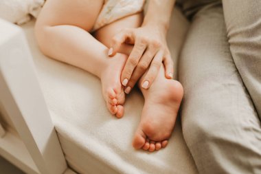 Bebek ayakları annenin ellerinde, küçük bebek ayakları, anne ve bebeği, annelik ve aile imajı..